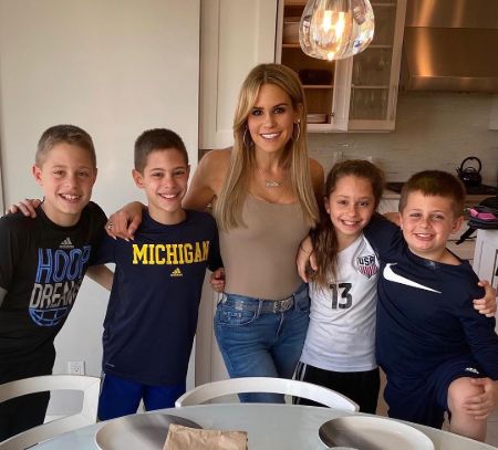 Jackie Goldschneider in brown top poses for a picture with her four children.